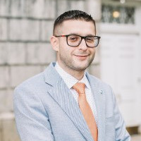 A man smiles while posing for a headshot.