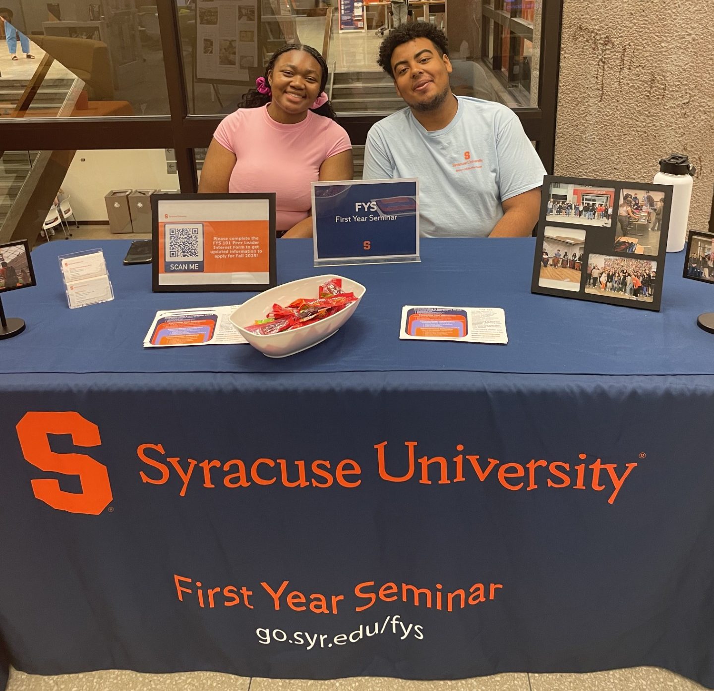 Two students smile while posing for a photo.