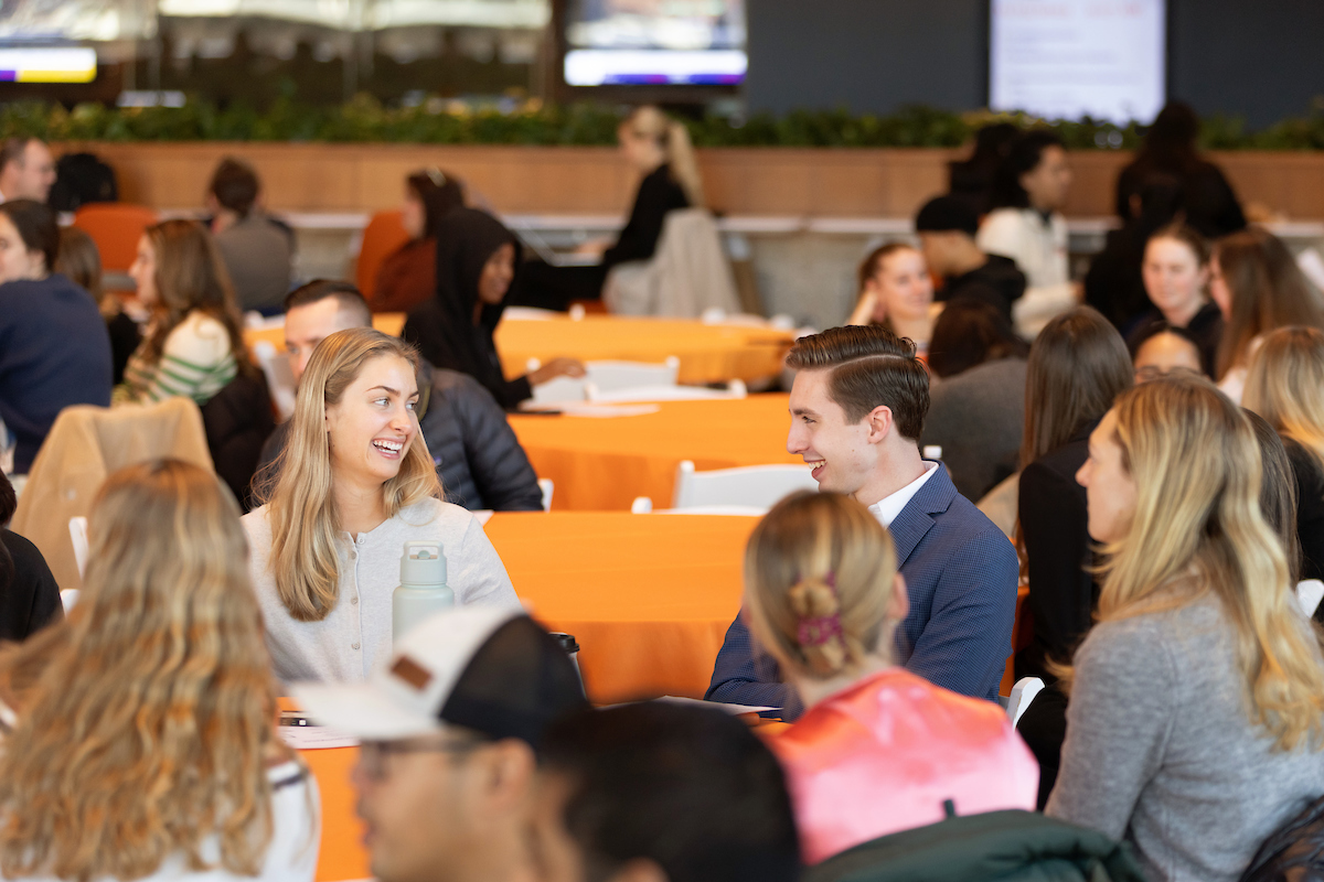 Attendees engaging in conversation at a busy networking event.