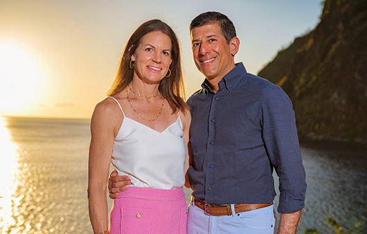 two people standing near large body of water