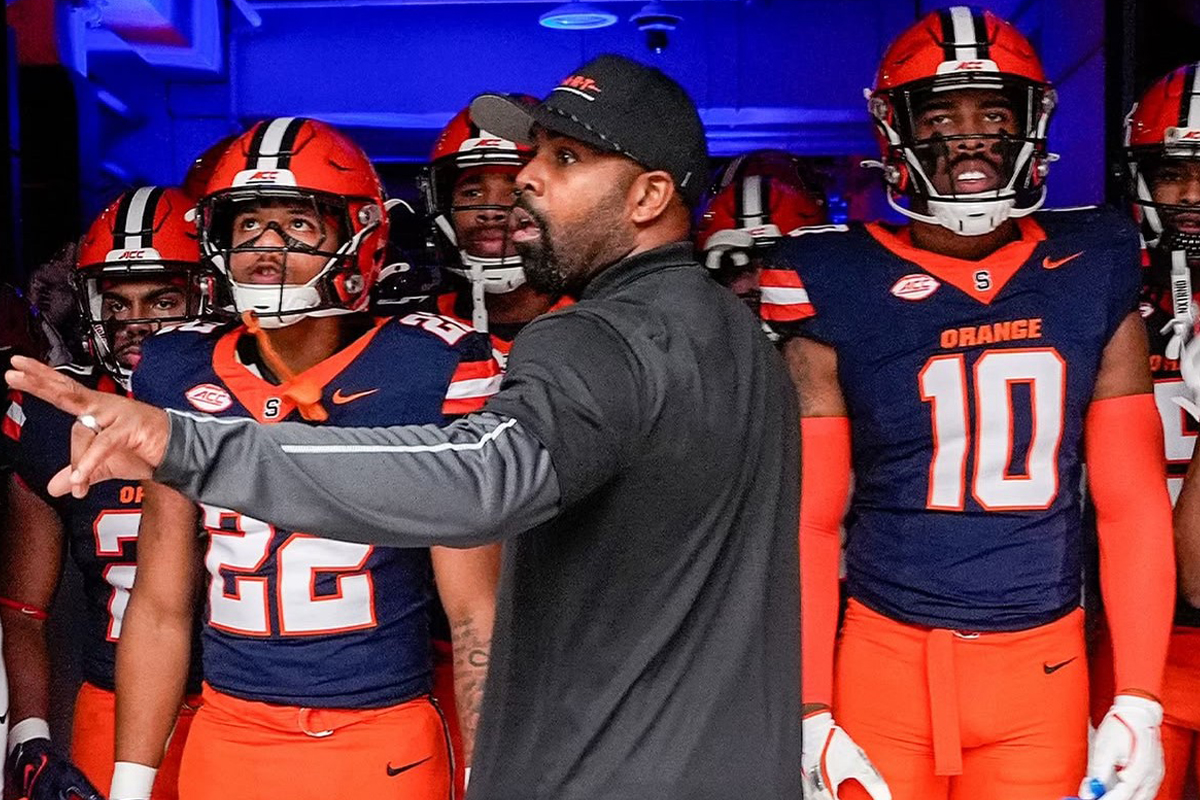 A football coach talks with his players before running onto the field.