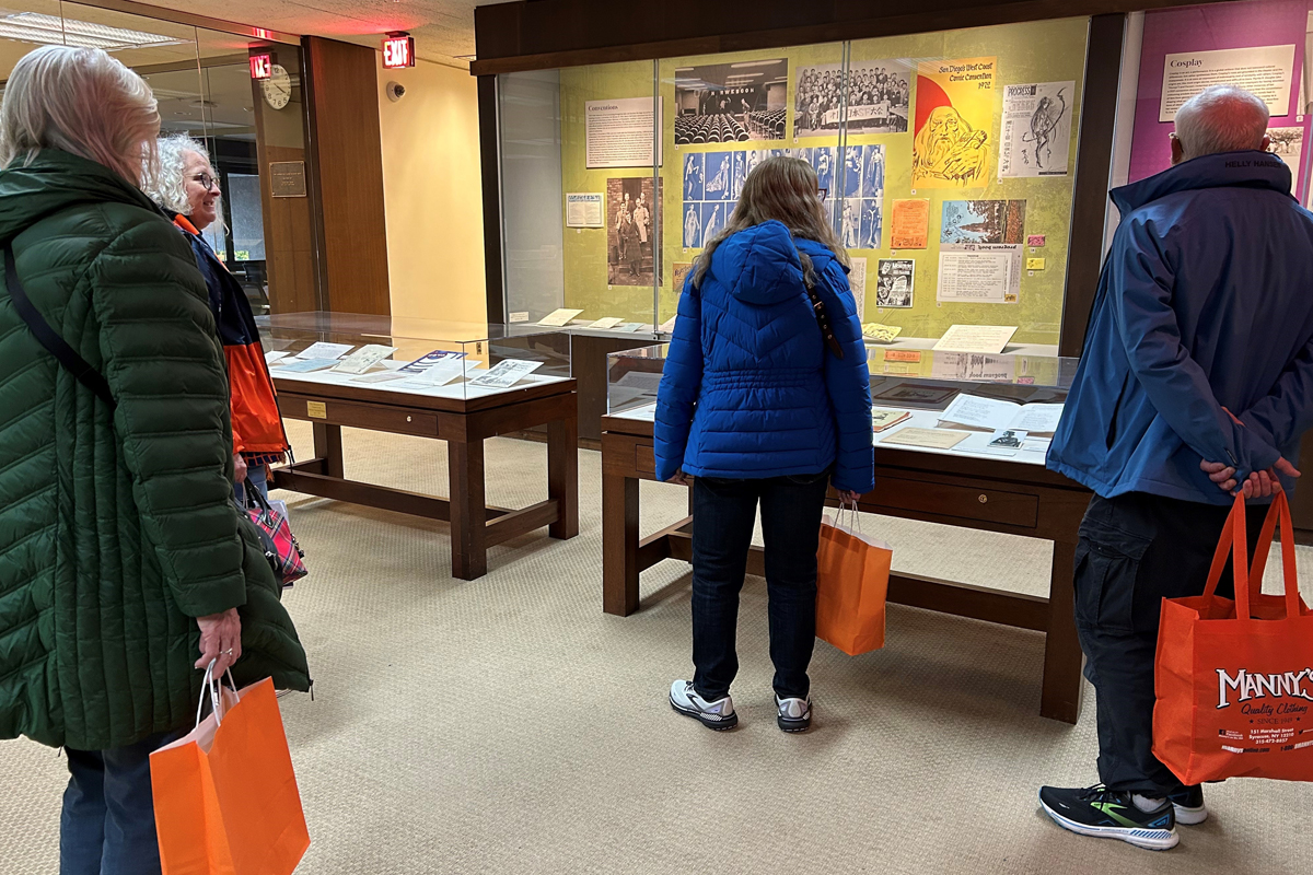 People observe an exhibit of documents during a program at Bird Library.