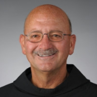 A man smiles while posing for a headshot.