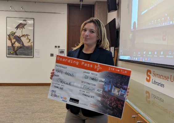 Student poses with boarding pass for ACC InVenture competition