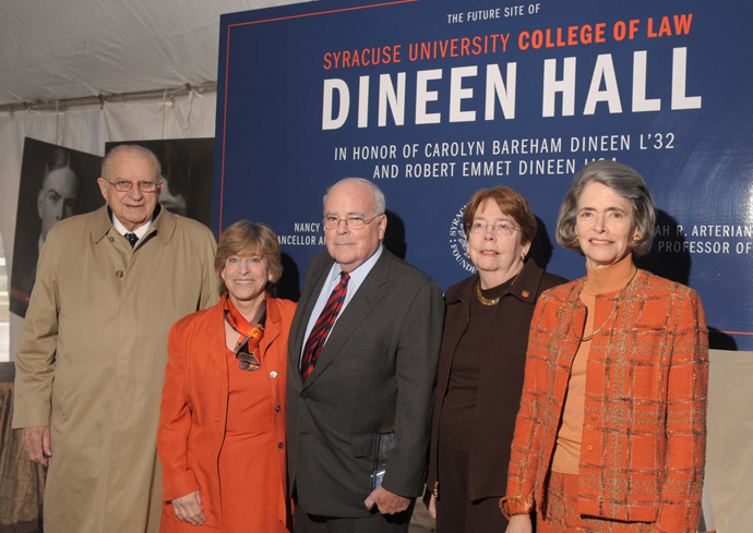 Five individuals pose in front of a sign for Dineen Hall.