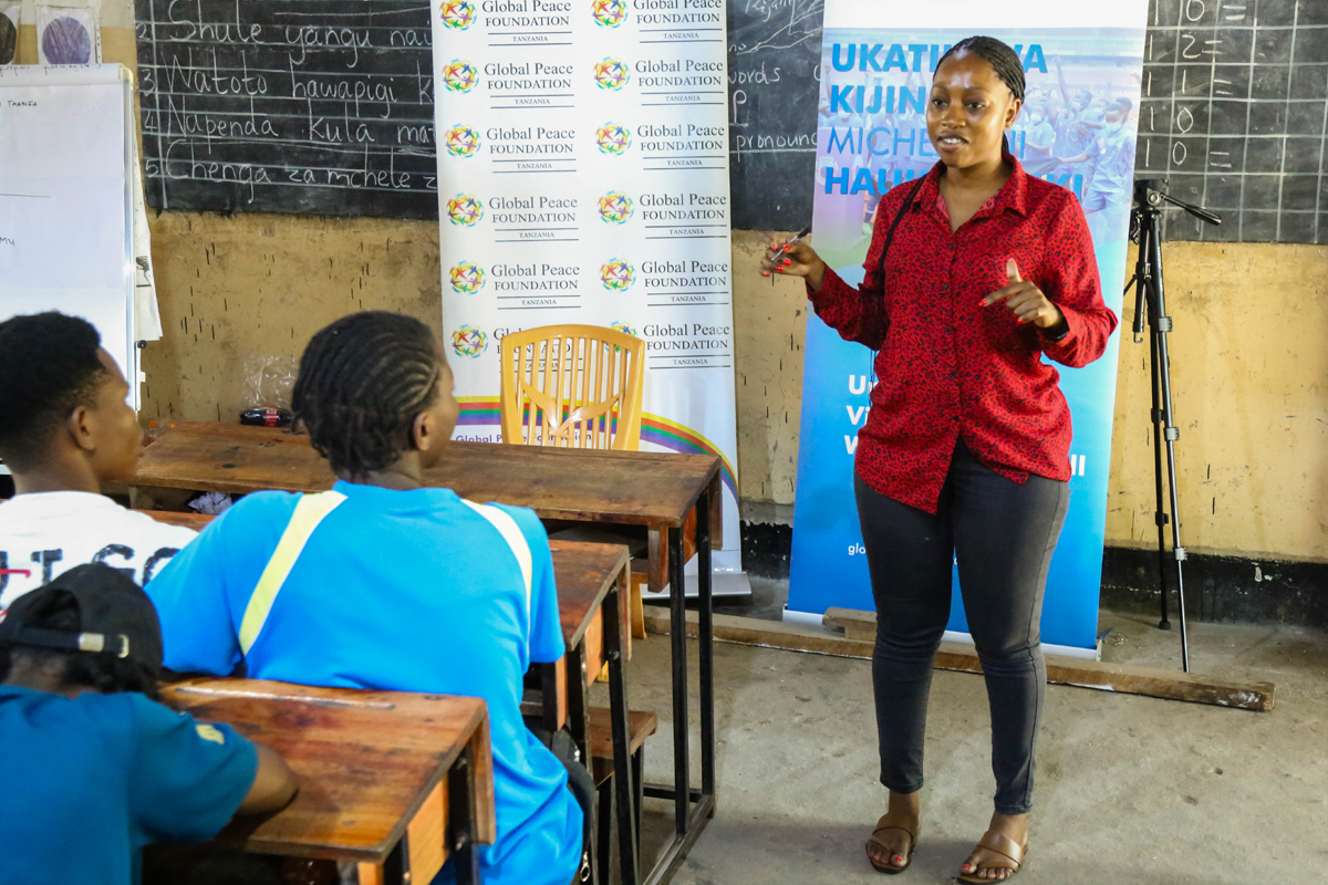 A woman speaks to a class of students in Tanzania.