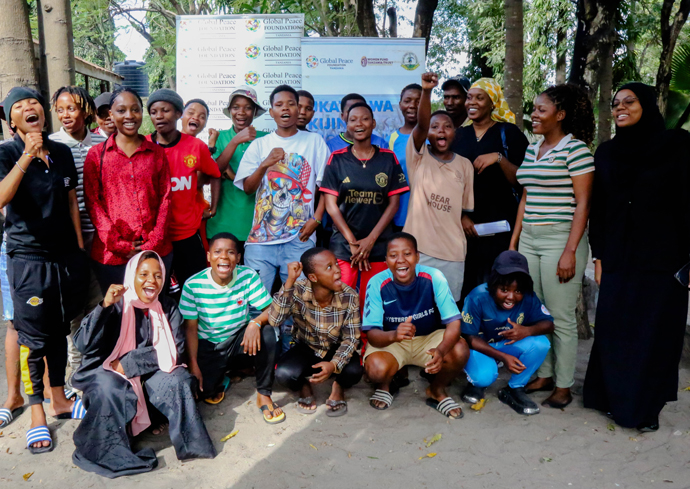 A group of people smile while posing for a group photo in Tanzania.