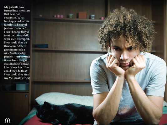 A teenager holds his head in his hands.