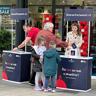 People receive a brochure from a walk-up stand.