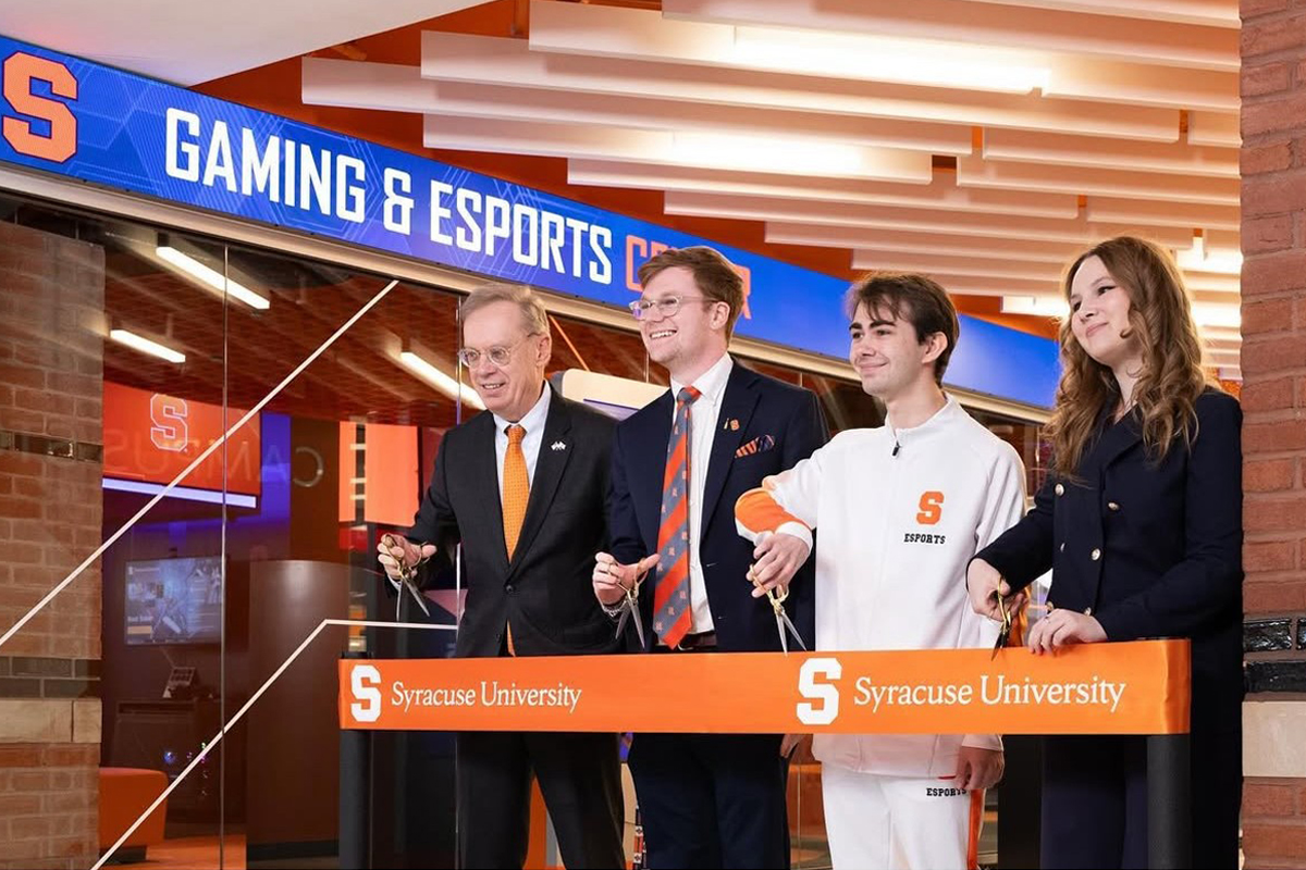 Four people hold scissors during a ribbon cutting ceremony for the Gaming and Esports Center.