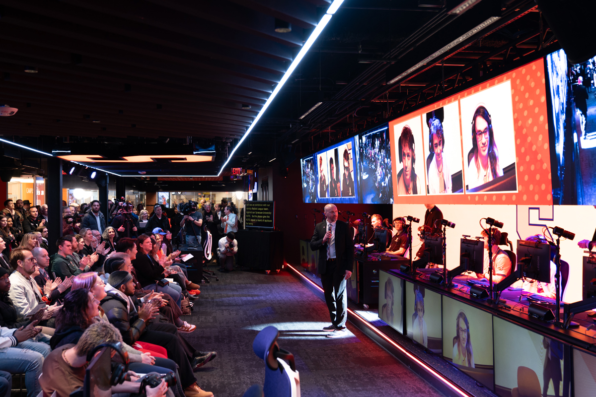 A man speaks to an audience during the grand opening of the gaming and esports center on the Syracuse University campus.