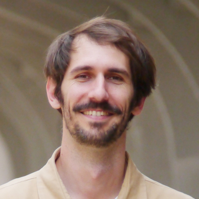 A man smiles while posing for a headshot.