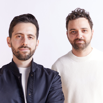 Two gentlemen pose for a group photo.