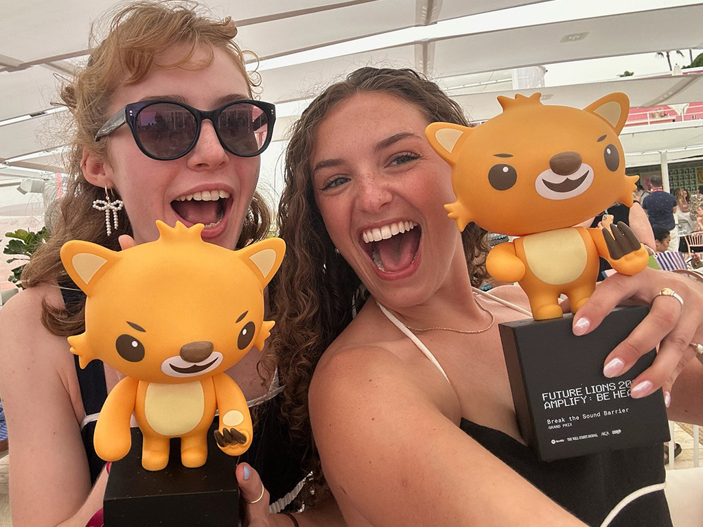 two people holding trophies