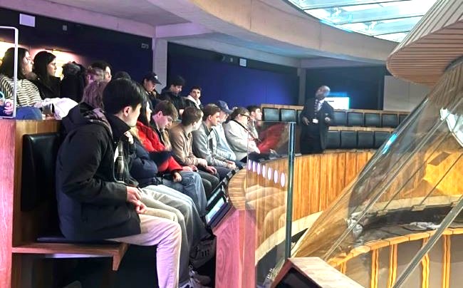 group of students seated in a window-walled observation desk at Welsh parliament