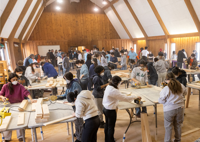 Students work on building bed frames for children's beds during Sleep in Heavenly Peace bed build