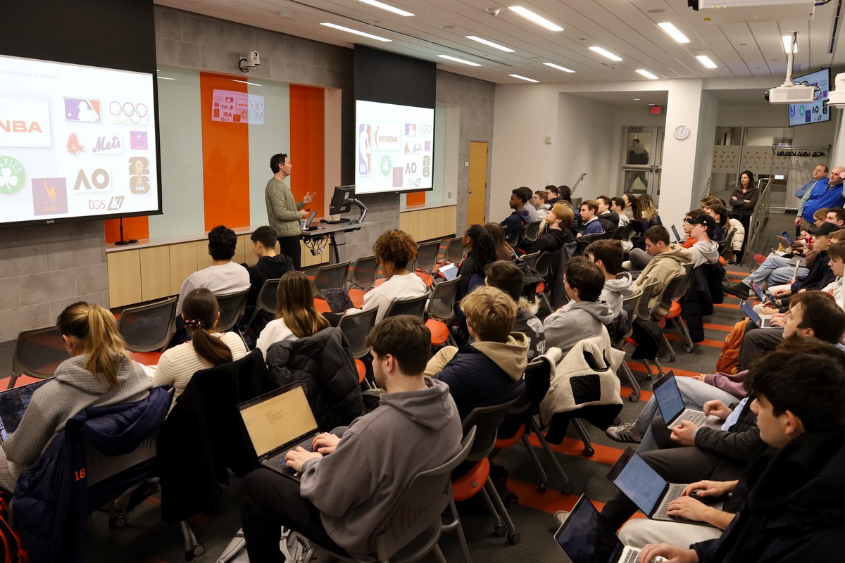 Students in a classroom listen to Dominick Fabrizio '99, marketing director of New Balance.