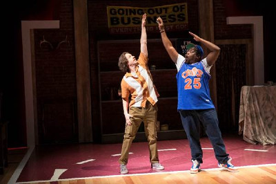 Two young men on a basketball court with their arms raised above their heads