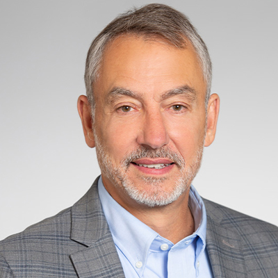 A person smiles while posing for a headshot.