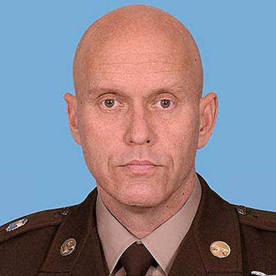 A military officer poses for a headshot in uniform.