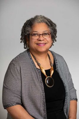 A professor smiles while posing for a headshot.