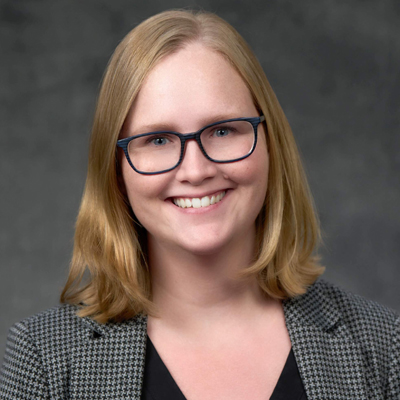 A person smiles while posing for a headshot