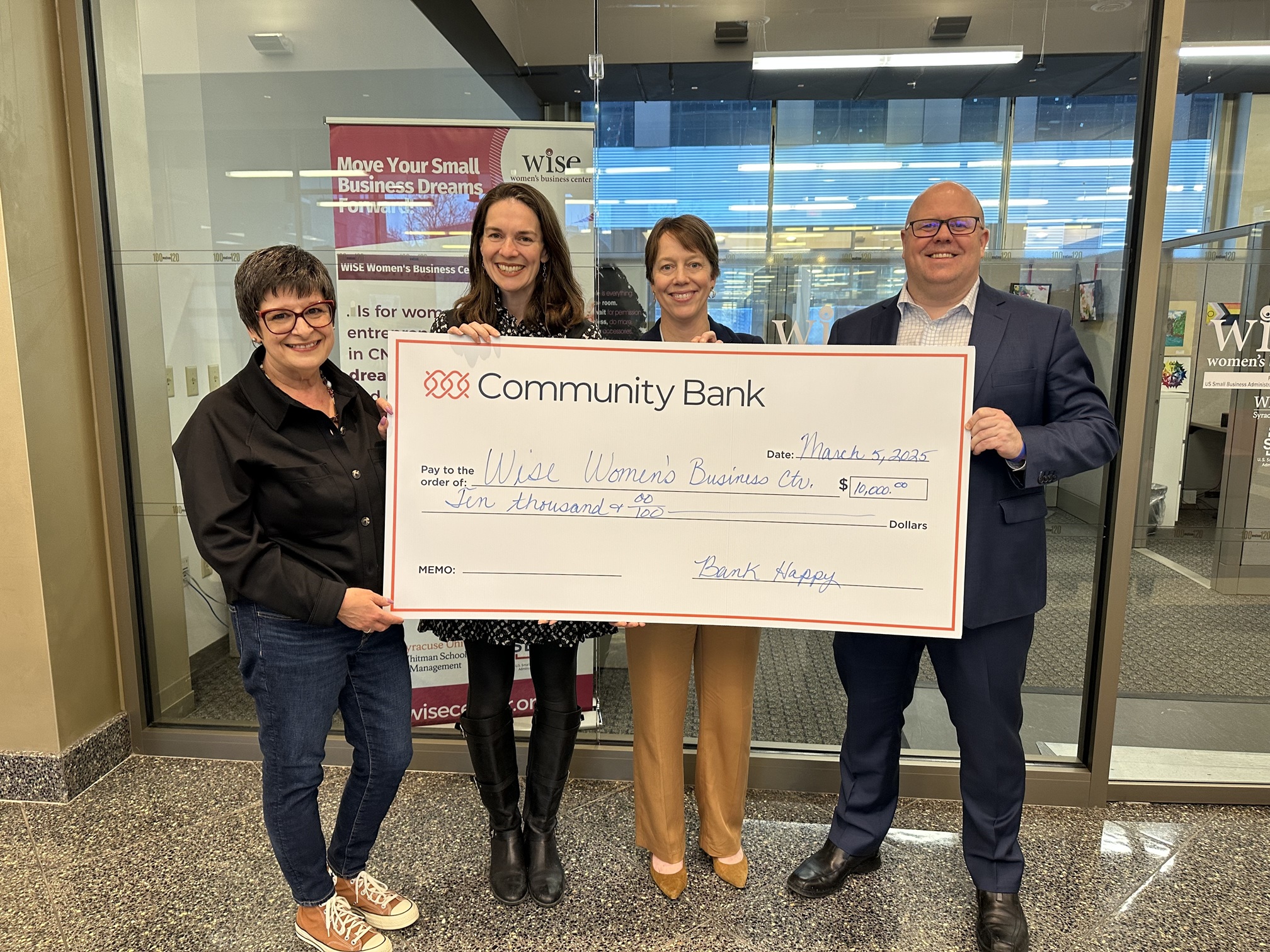 four people holding oversized check