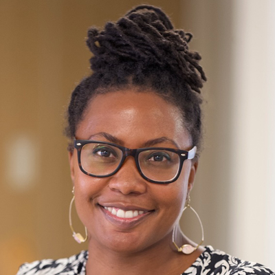 A person smiles while posing for a headshot.