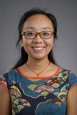 A professor smiles while posing for a headshot.