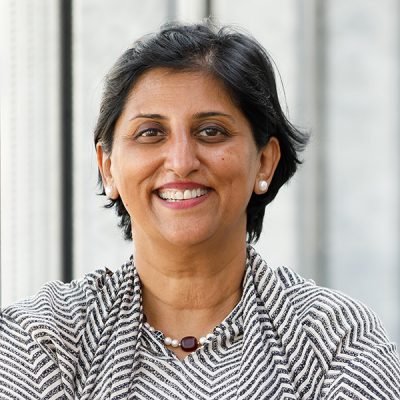 A person smiles while posing for a headshot