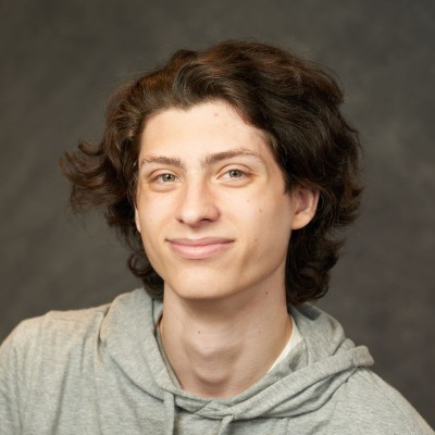 A student smiles while posing for a headshot.