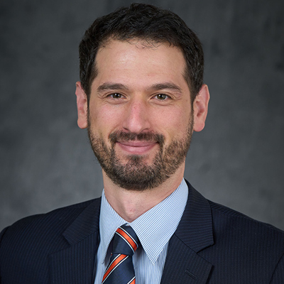 A person smiles while posing for a headshot.