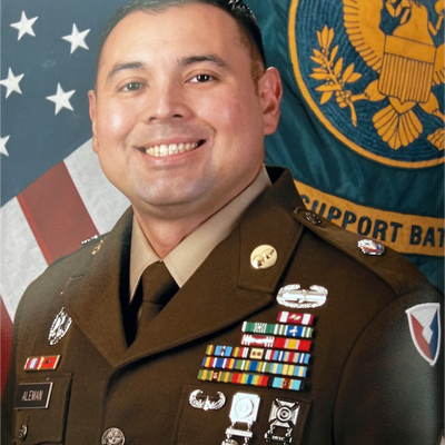 A person smiles for a headshot while in their military uniform.