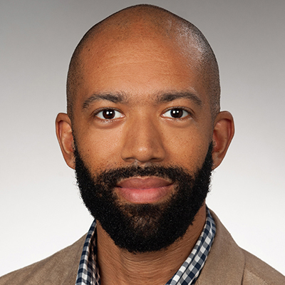 A person smiles while posing for a headshot