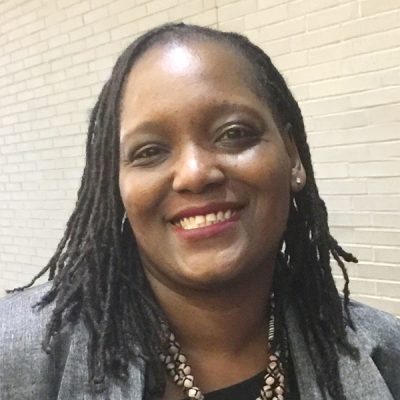 A person smiles while posing for a headshot.