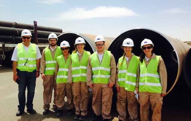 seven people in safety vests and hard hats standing