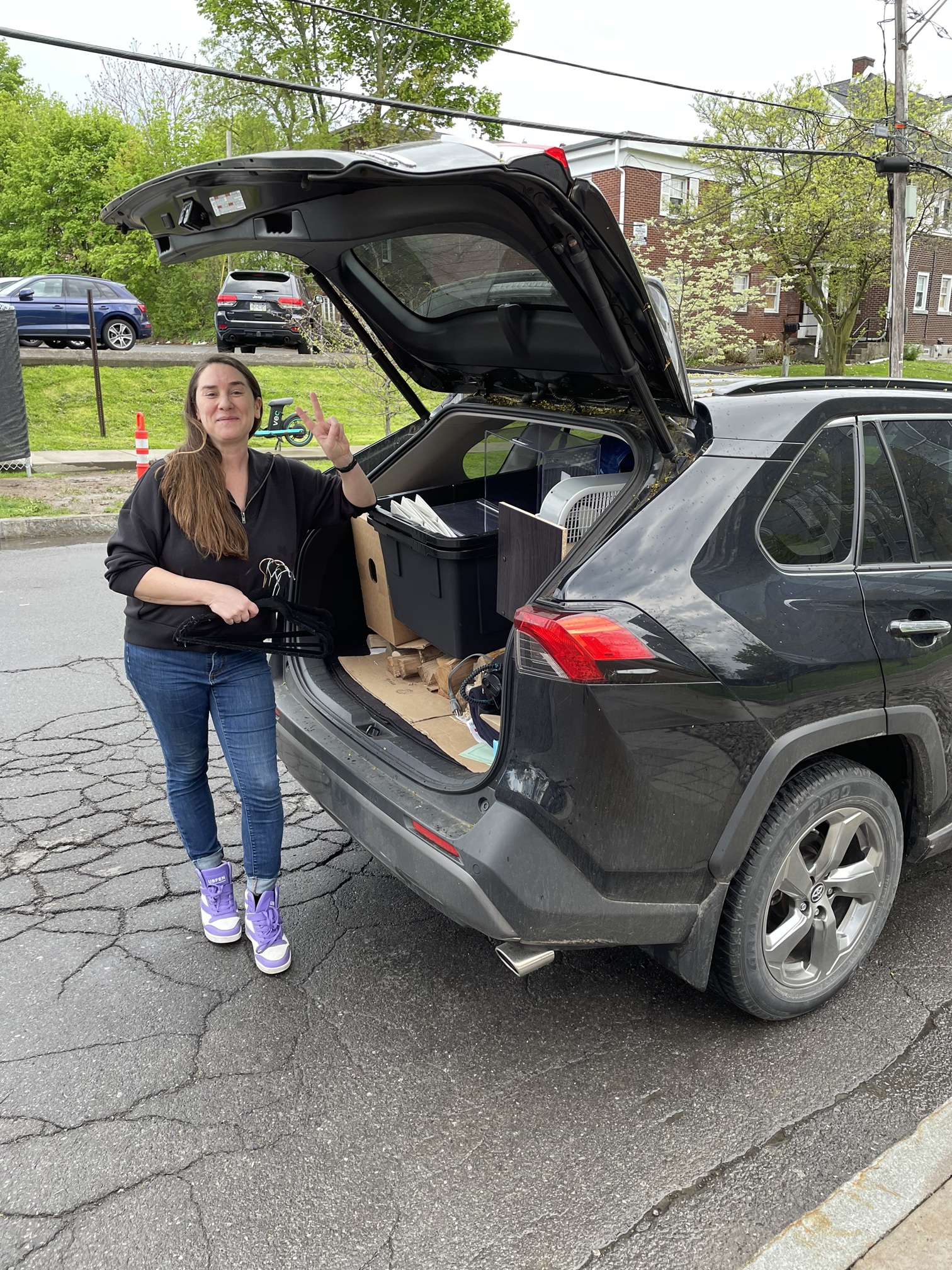 person standing next to vehicle with trunk open