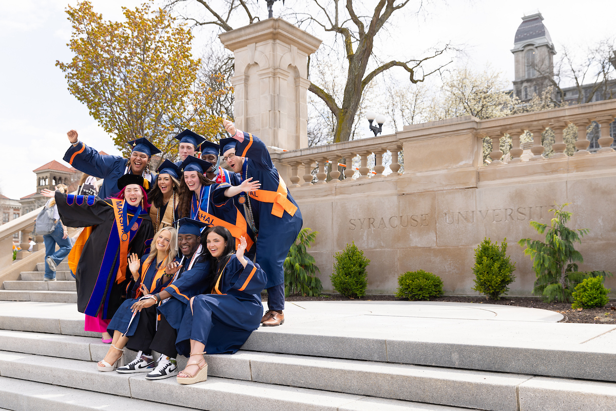 group of people in academic regalia posing on steps