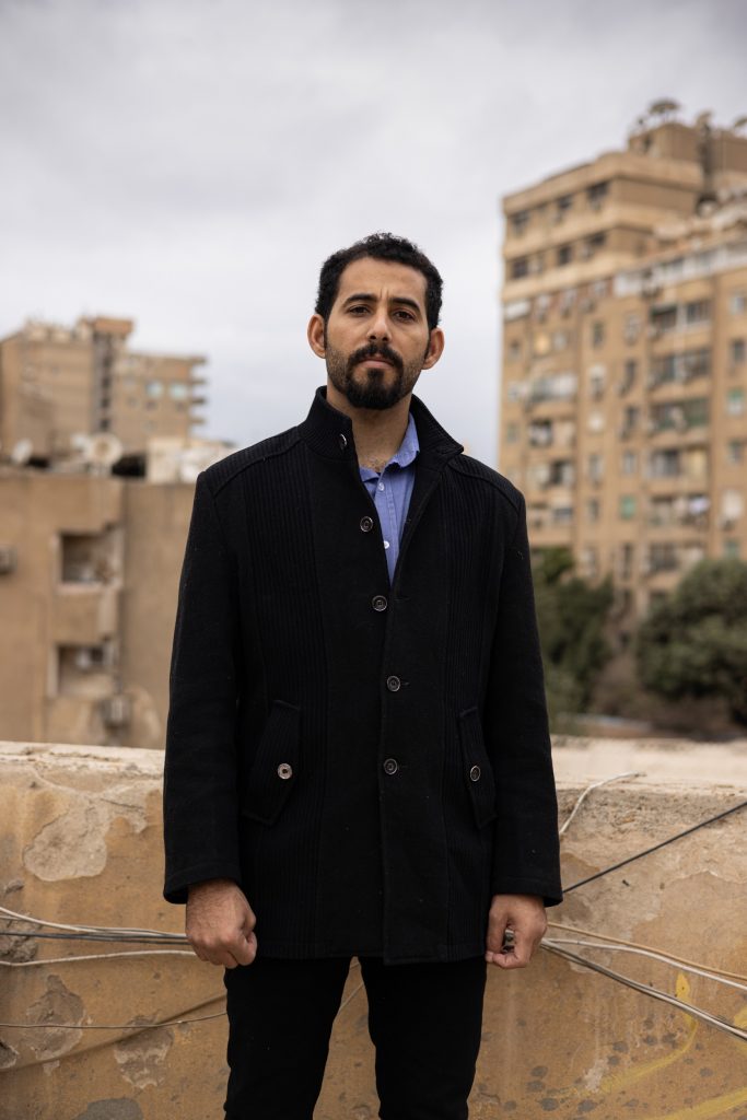 person standing outside in front of high-rise buildings