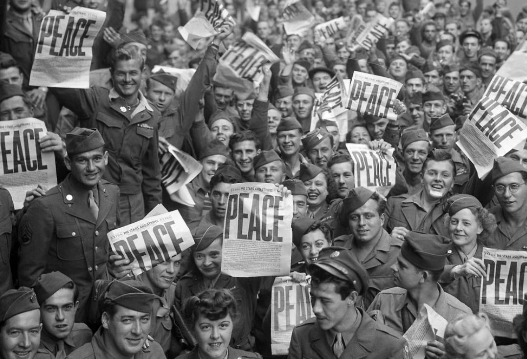 VE Day celebration photo: Soldiers hold up the Stars and Stripes newspaper in celebration of the end of WWII in Europe May 8, 1945.