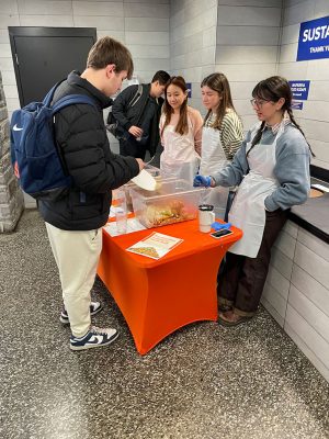 students gathered around a table with food on it
