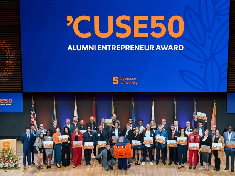 Members of the 2024 'CUSE50 cohort are pictured on stage with Otto