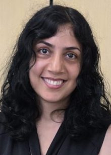 person with long dark hair and dark eyes looking forward, smiling