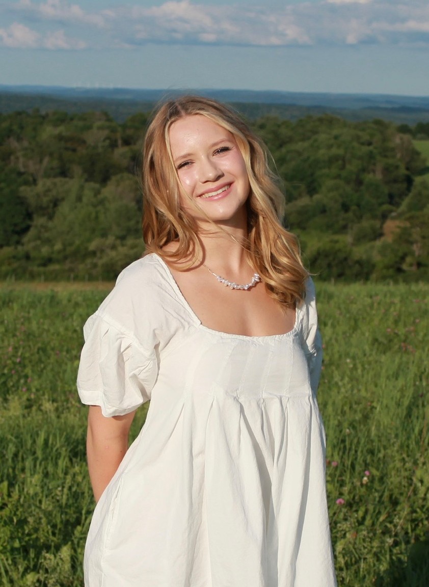 Young woman in a white dress with a scenic background