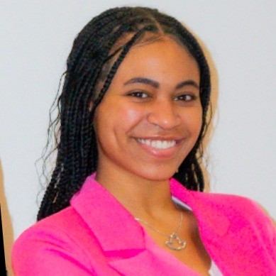 A smiling student wearing a bright pink blazer, photographed against a white background in a professional headshot style.