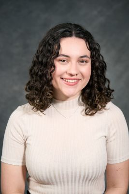 Woman wearing while blouse and is smiling