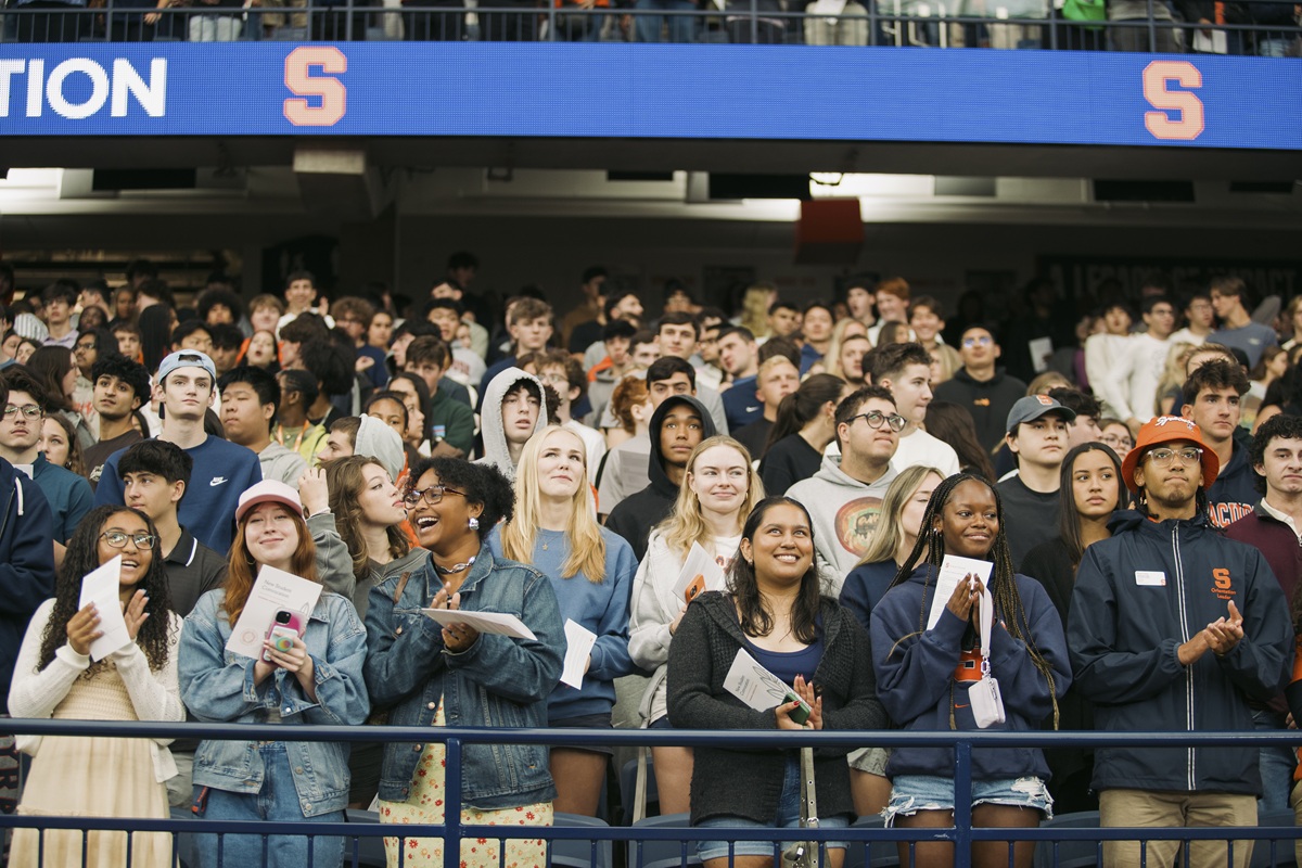 large group of people standing in a stadium or arena, facing forward