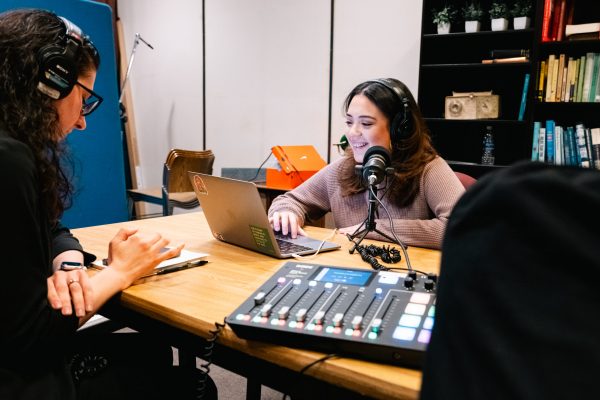 Young women wearing headphones record a podcast in a studio
