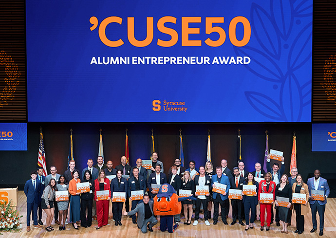 Members of the 2024 'CUSE50 cohort are pictured on stage with Otto