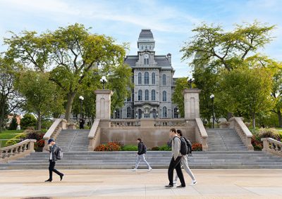 Students walking along the Einhorn Walk with the Hall of Languages in the background